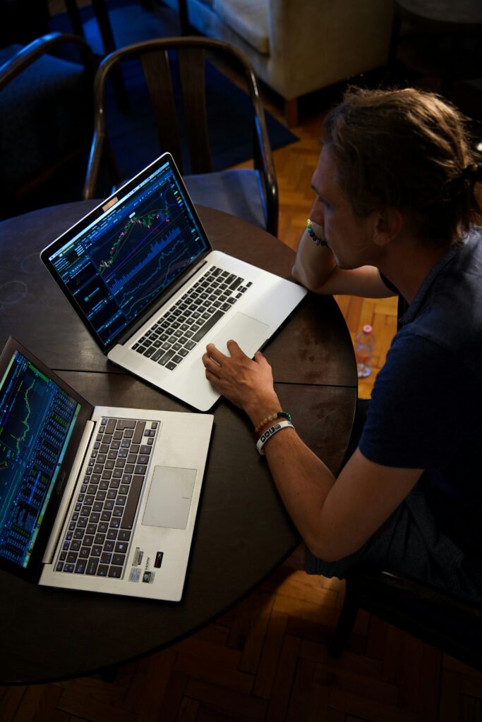 A man sitting in front of two macbook pros