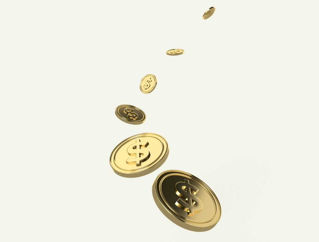 A few coins falling down from above on a blank background