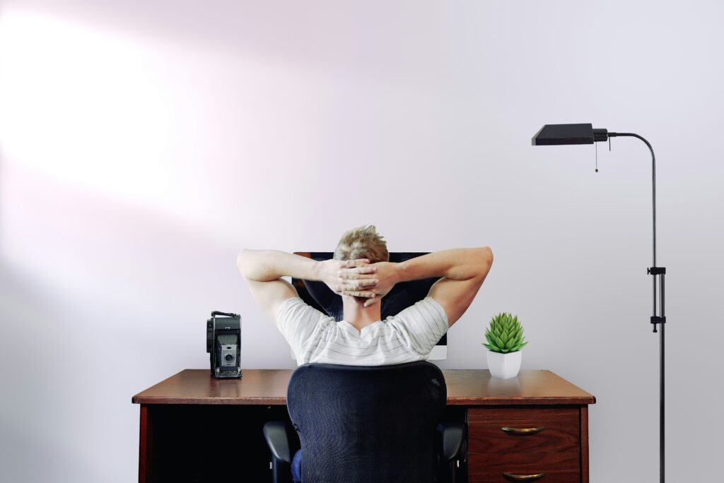 A man stretching back whilst sat at his desk
