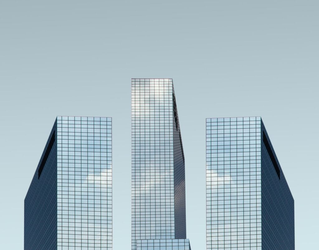 Three glass skyscrapers against a dull sky
