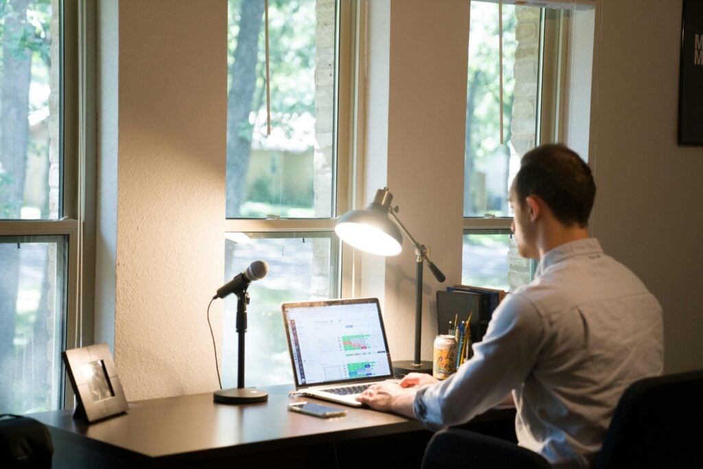 A man sat at his desk, looking at a computer