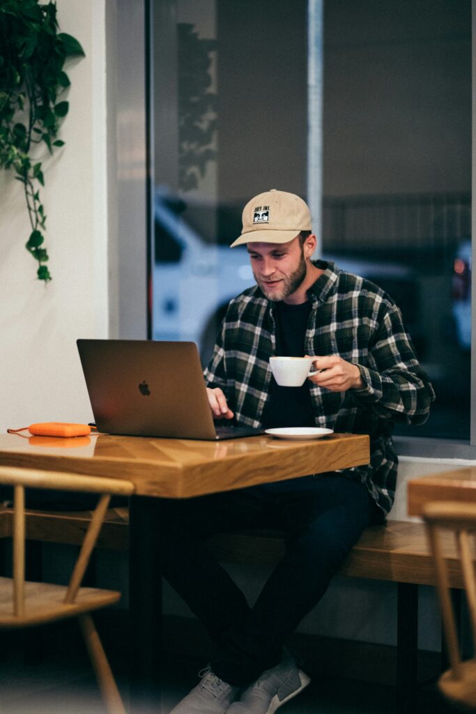 A man wearing a hat working on his computer