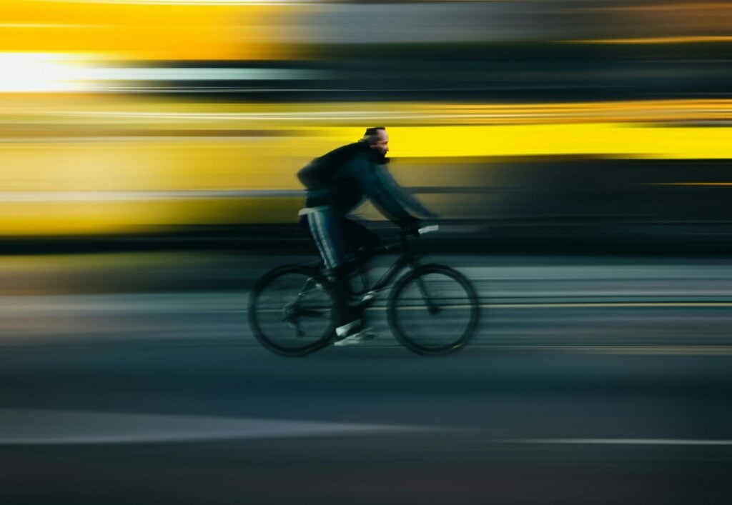 A man cycling quickly on his bike with a blurry background