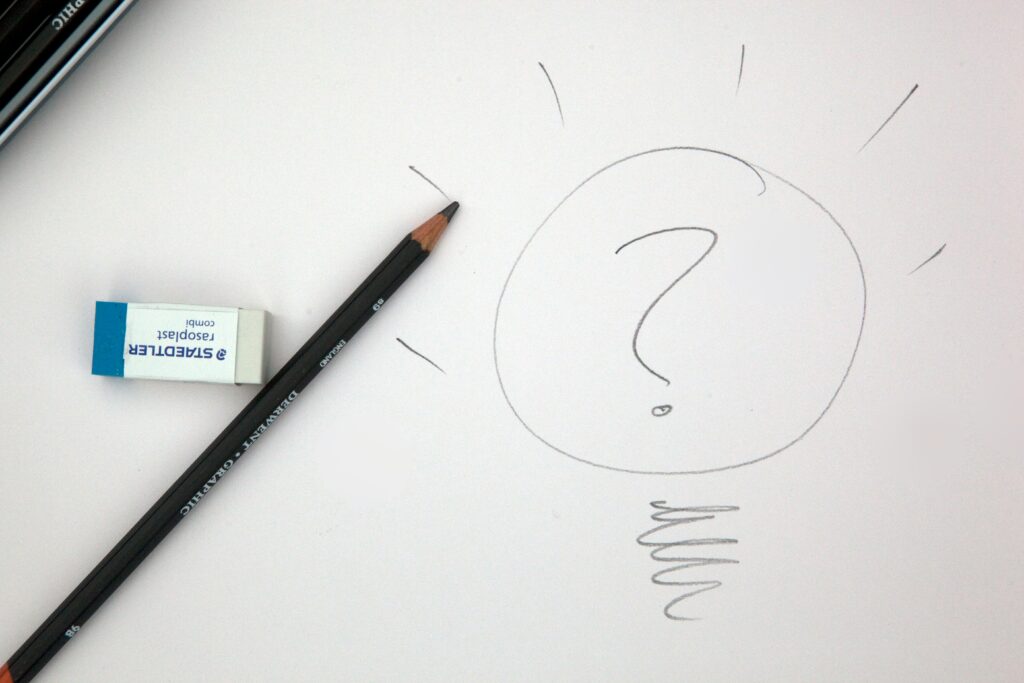 A pencil drawing a lightbulb with an eraser